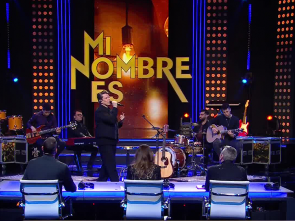Andrés de León sobre el escenario de Mi Nombre Es acompañado de su banda.